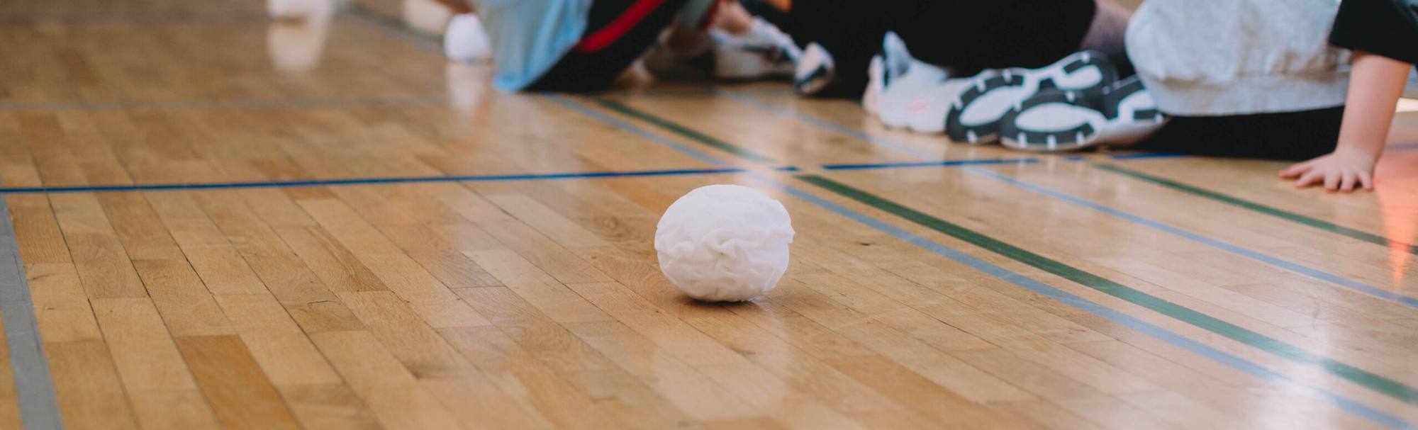 A single white Dry Snowball on a gymnasium floor